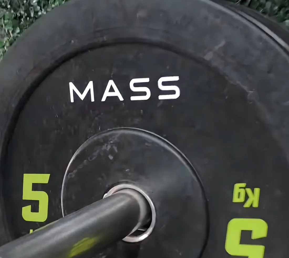 Primer plano de una pesa con el logo MASS y el número 5 kg